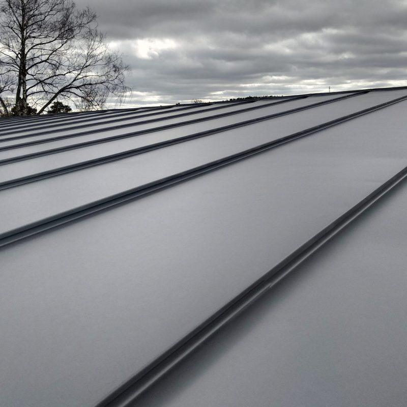 Close-up detail of house roof made from gray metal sheets.